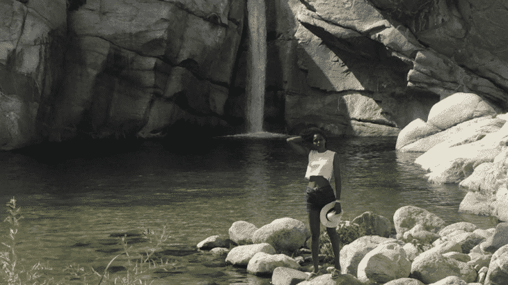 girl standing in front of a waterfall