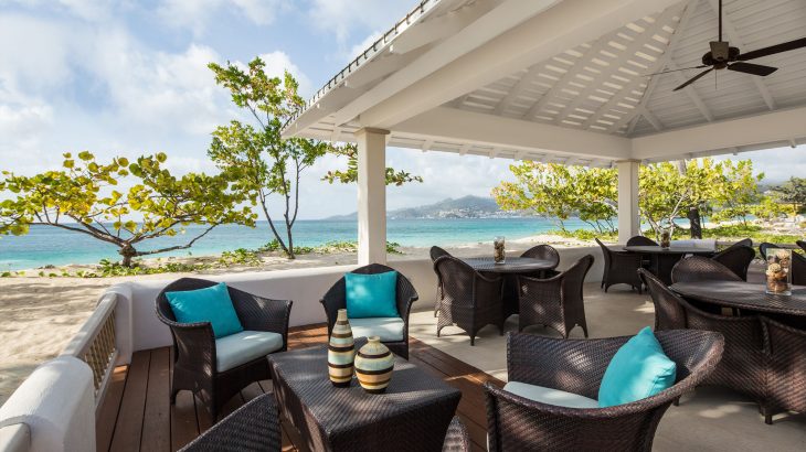 outdoor seating at a restaurant overlooking the ocean at Spice Island Beach Resort