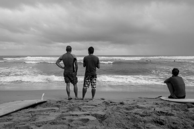 Surfing in the Caribbean in D. R. Surfers take a break to assess conditions on Playa Encuentro in the Dominican Republic.