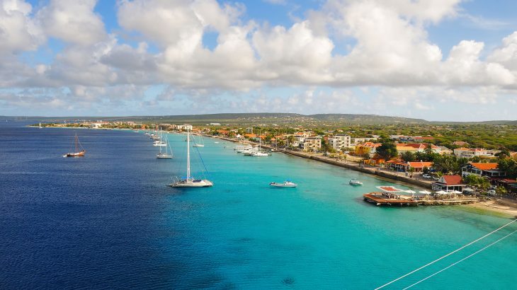 The island of Bonaire from above with blue water and sail boats and the land in the background