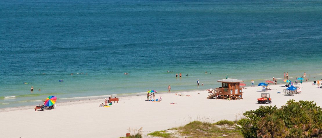 Aerial view of white sand beach with lifeguard huts and the ocean