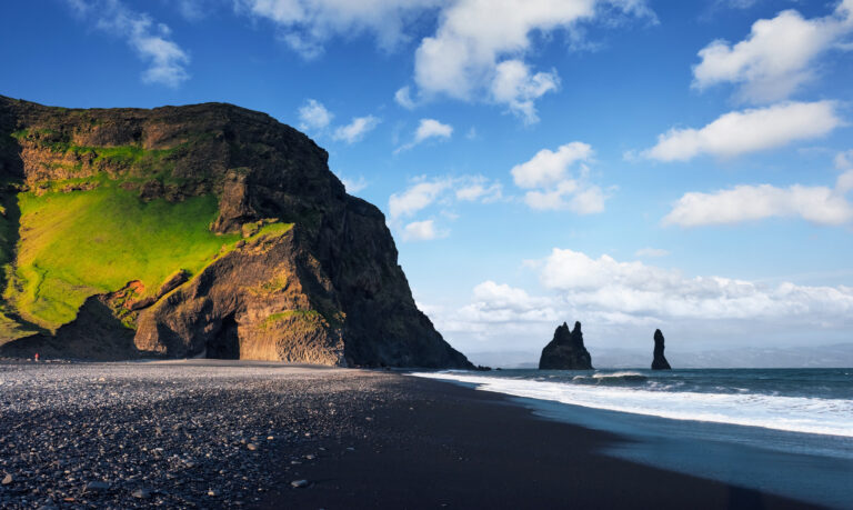 Famous Reynisdrangar rock formations at black Reynisfjara Beach. Coast of the Atlantic ocean near Vik, southern Iceland.