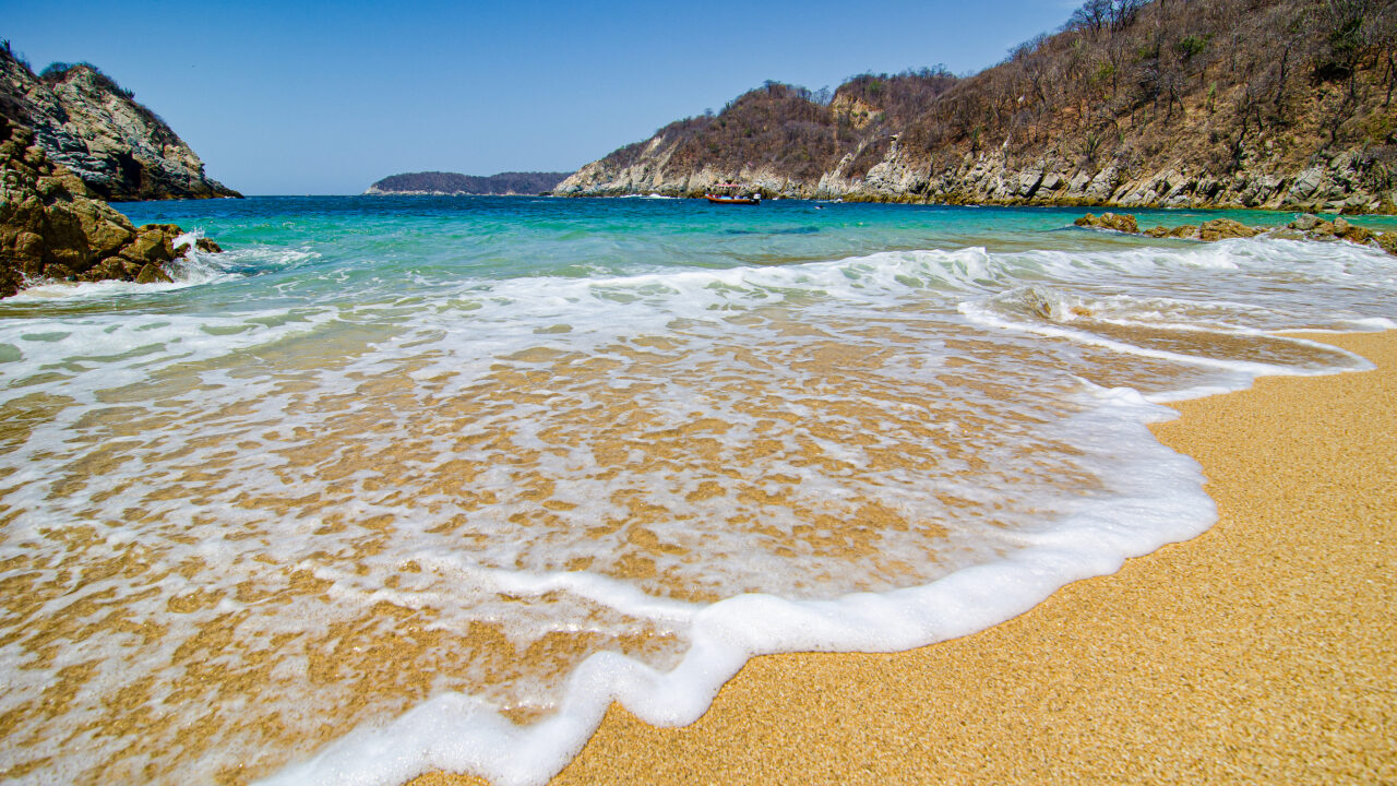 Paradise sand beach with turquoise blue water in Huatulco, Oaxaca, Mexico.