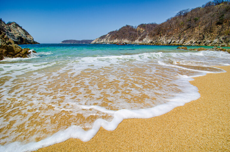 Paradise sand beach with turquoise blue water in Huatulco, Oaxaca, Mexico.