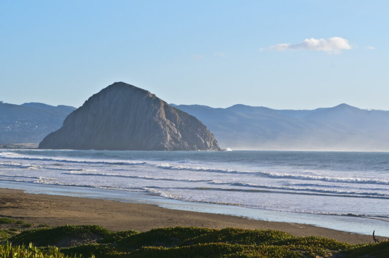 Morro Rock, Central Coast, California. Morro Rock in Morro Bay, a major tourist destination on the central California coast, makes a stunning backdrop for the beach and ocean surf.