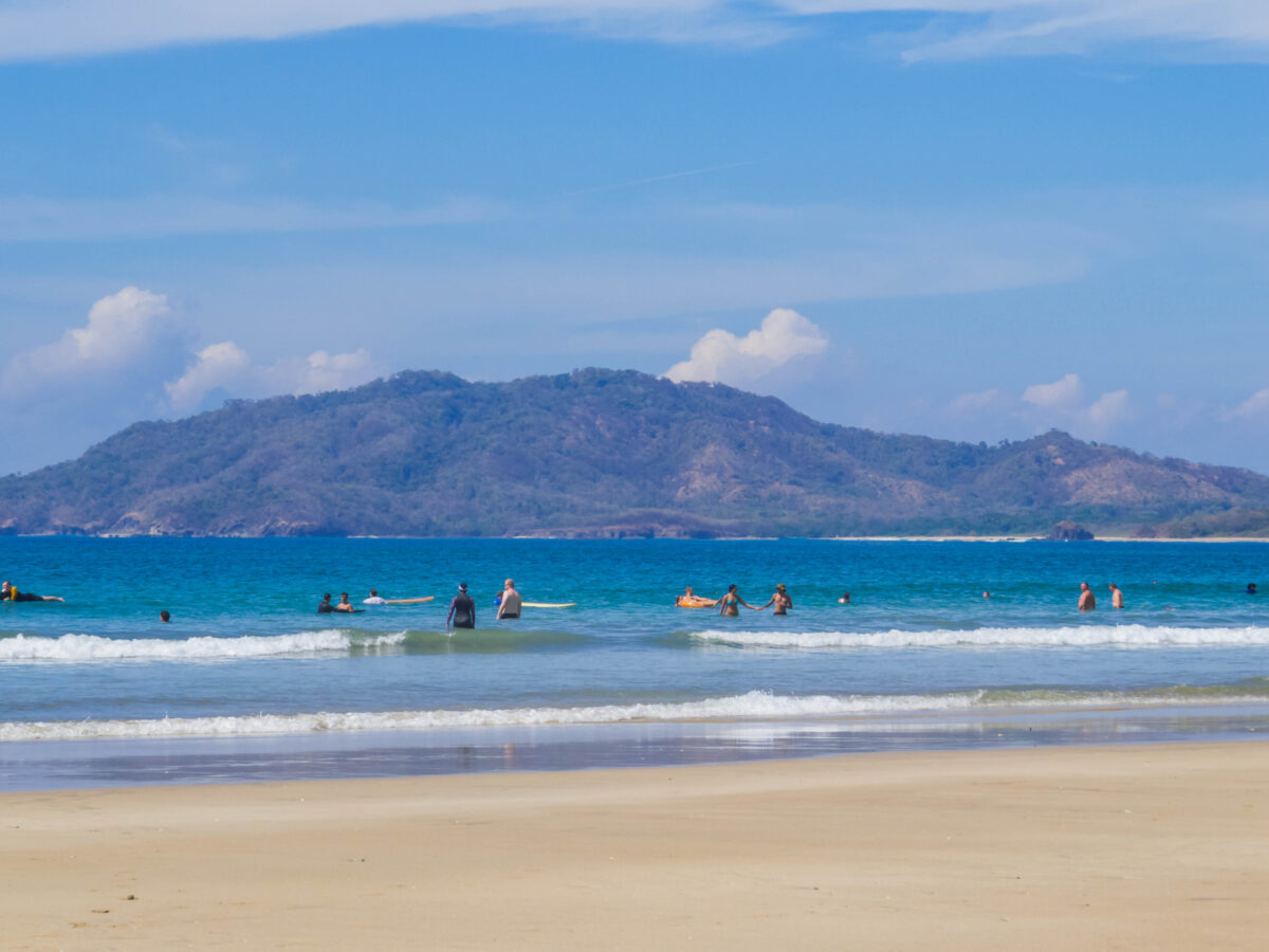 beachgoers playing in the water at Tamarindo Beach, Costa Rica