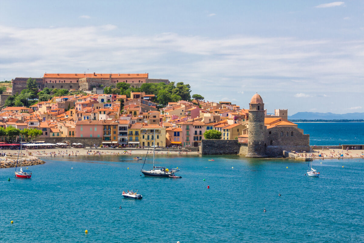 Tourists enjoy the beach of Collioure, coastal village in the south of France, Mediterranean sea, Languedoc Roussillon, Pyrenees Orientales.
