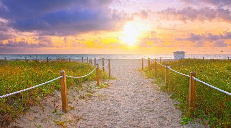 Path on the sand going to the ocean in Miami Beach, Florida, at sunrise.