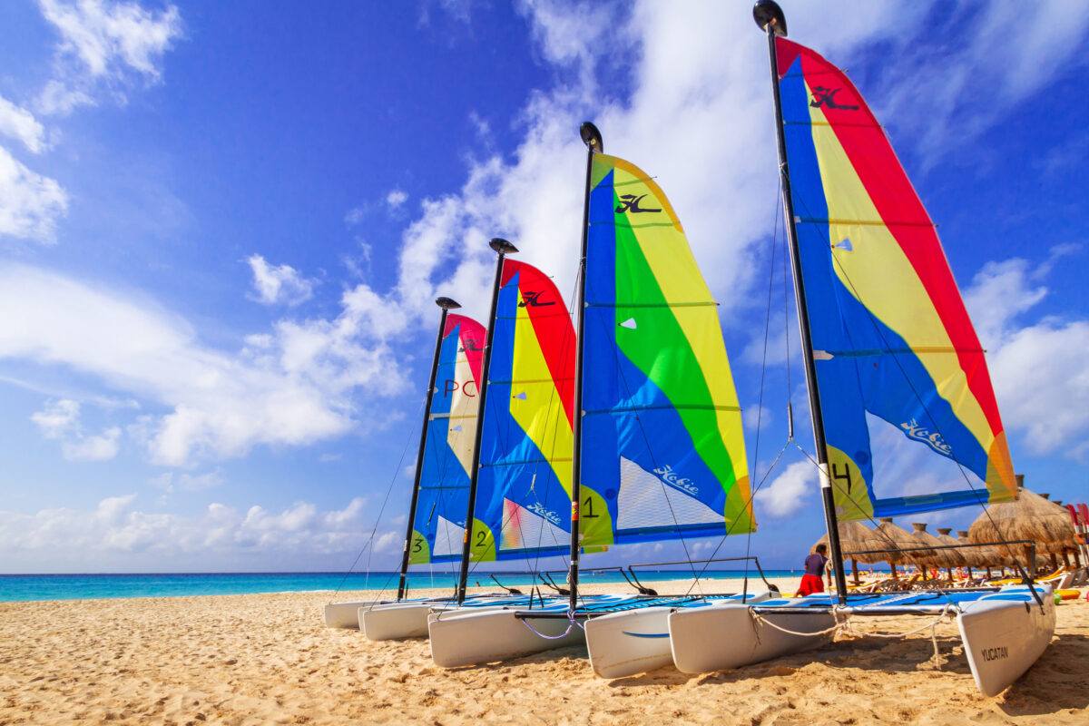 Colorful sail catamarans on the beach of Playacar at Caribbean Sea of Mexico. This resort area is popular destination with the most beautiful beache