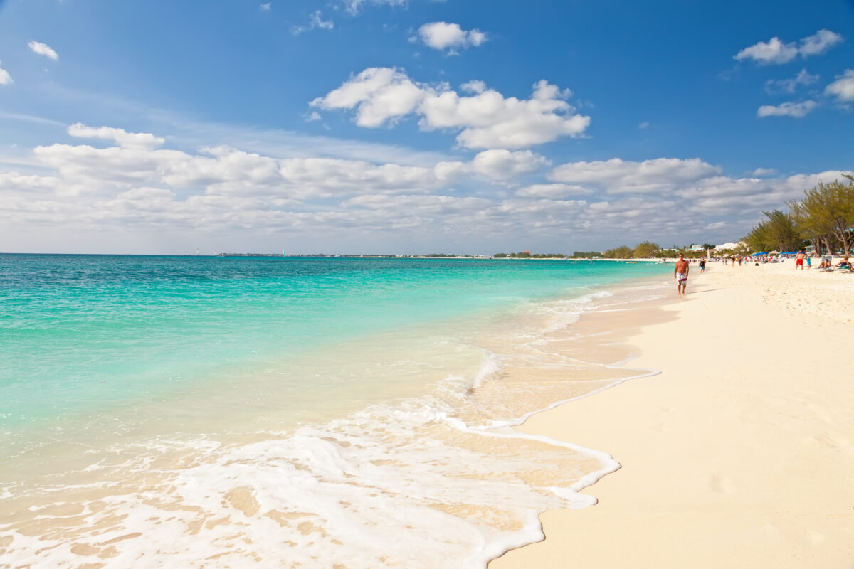 Man walking on Seven Mile Beach, Cayman Islands