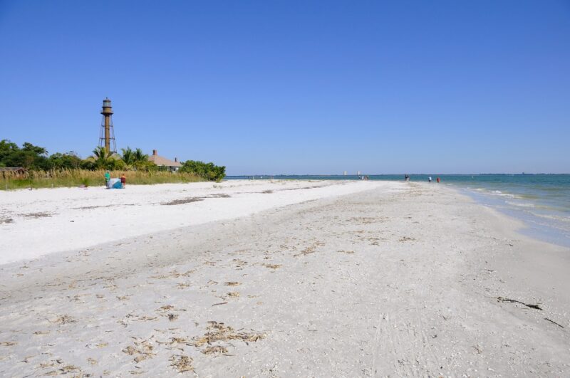 Sanibel Island Sandy Coast. Long beach and distant lighthouse on Sanibel Island in Florida