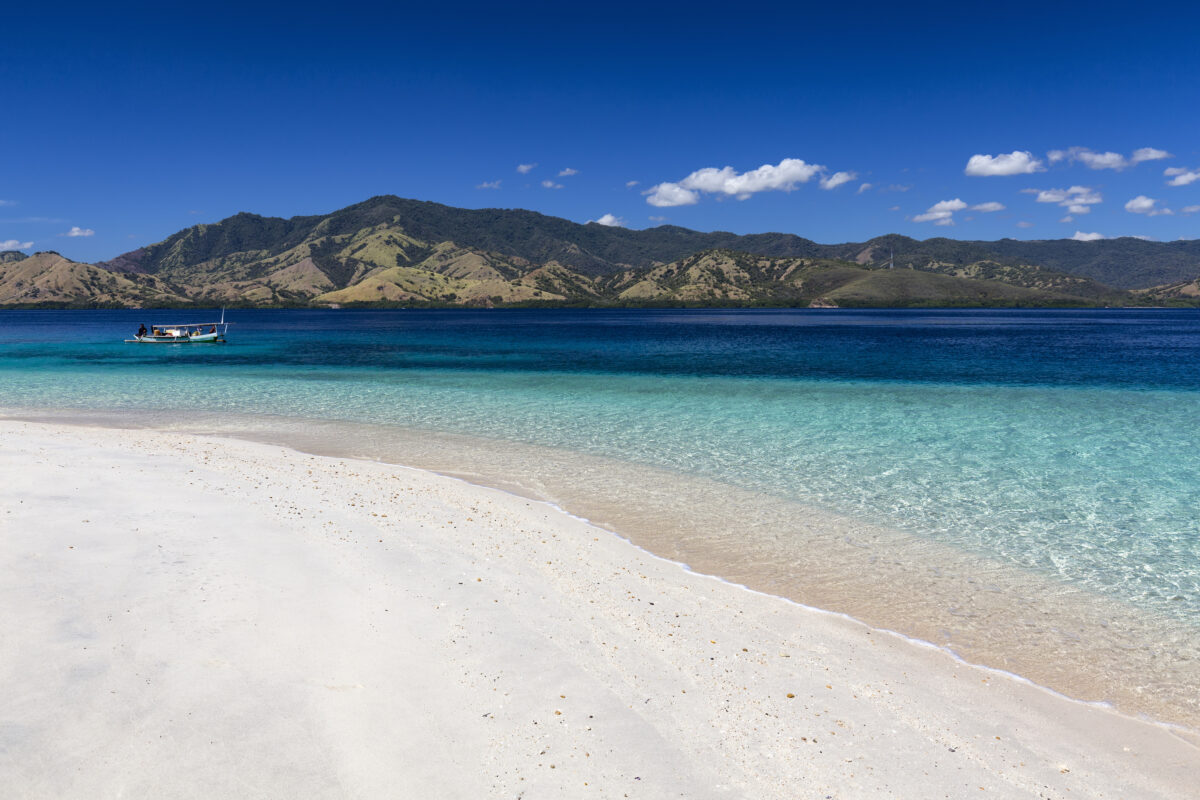 A small boat near an empty beach in the Seventeen Island National Park, Flores, Indonesia.