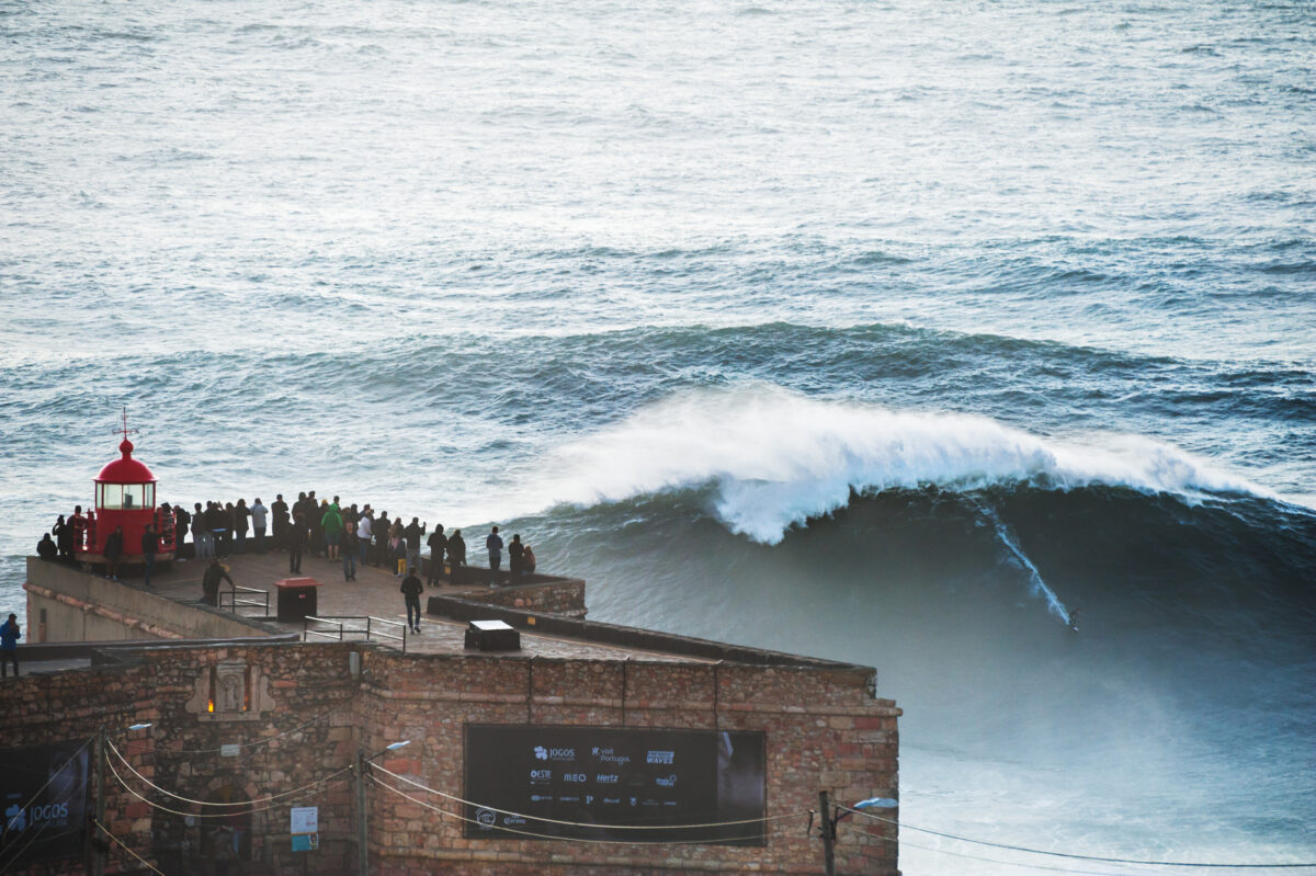 Surfer rides a big 15 meter wave on Praia do Norte beach in Nazare, Portugal. 