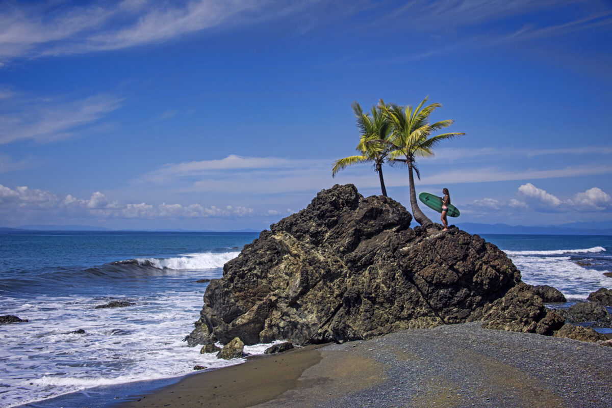 Surfer girl on Paradise beach watching the waves, Costa Rica.