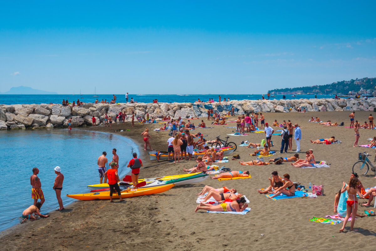 People relax, sunbathe and swim on Mappatella Beach on Quay of Via Francesco Caracciolo.