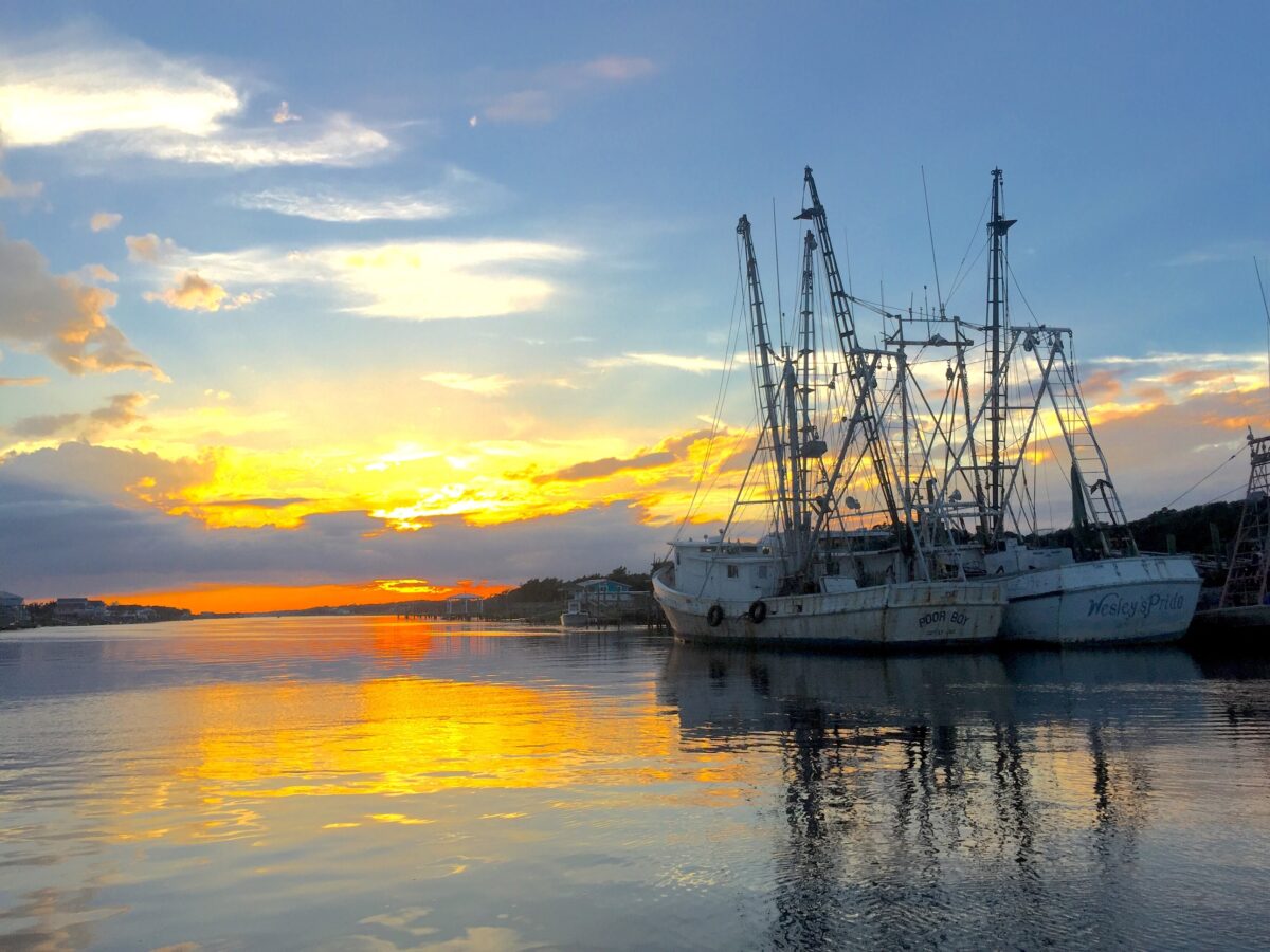 Harbor sunset view. Sun setting over the waterway at Holden Beach,North Carolina. With two shrimp fishing boats.
