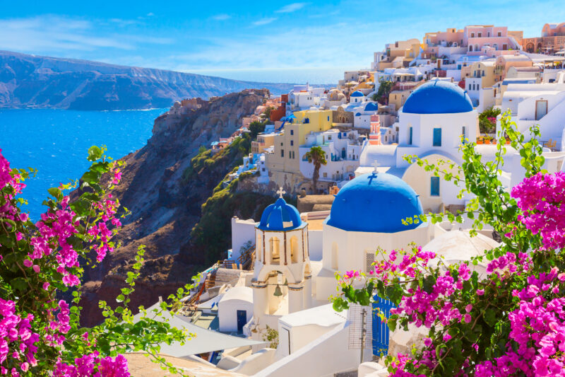 Oia town traditional white houses and churches with blue domes over the Caldera, Aegean sea