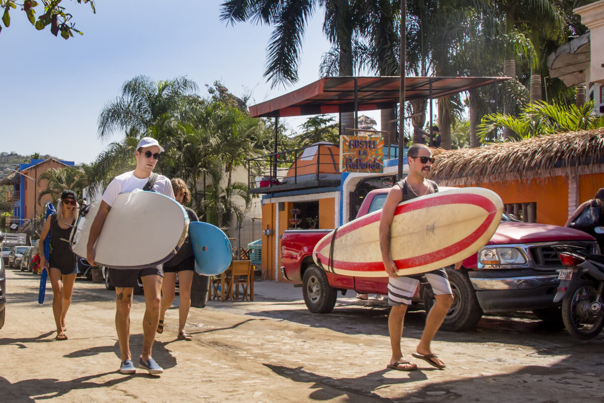 Tourist heading for a surfing session in Sayulita Beach in Mexico.