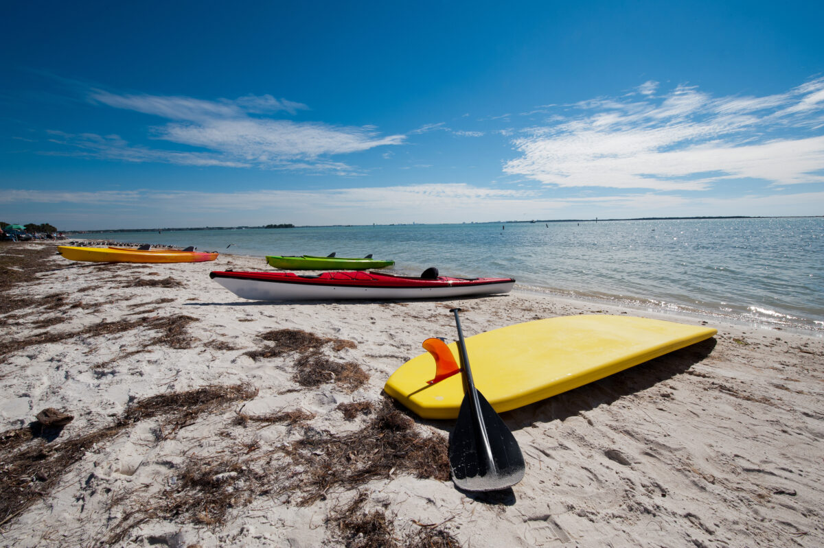 Kayaks and a surf board on a sandy beach of Honeymoon Island, Florida