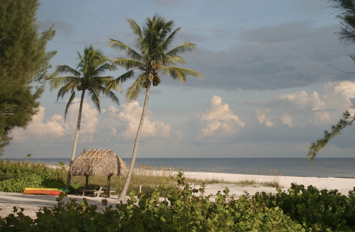 Beautiful photo of a picnic table under a grass hut on the island of Sanibel Florida. 
