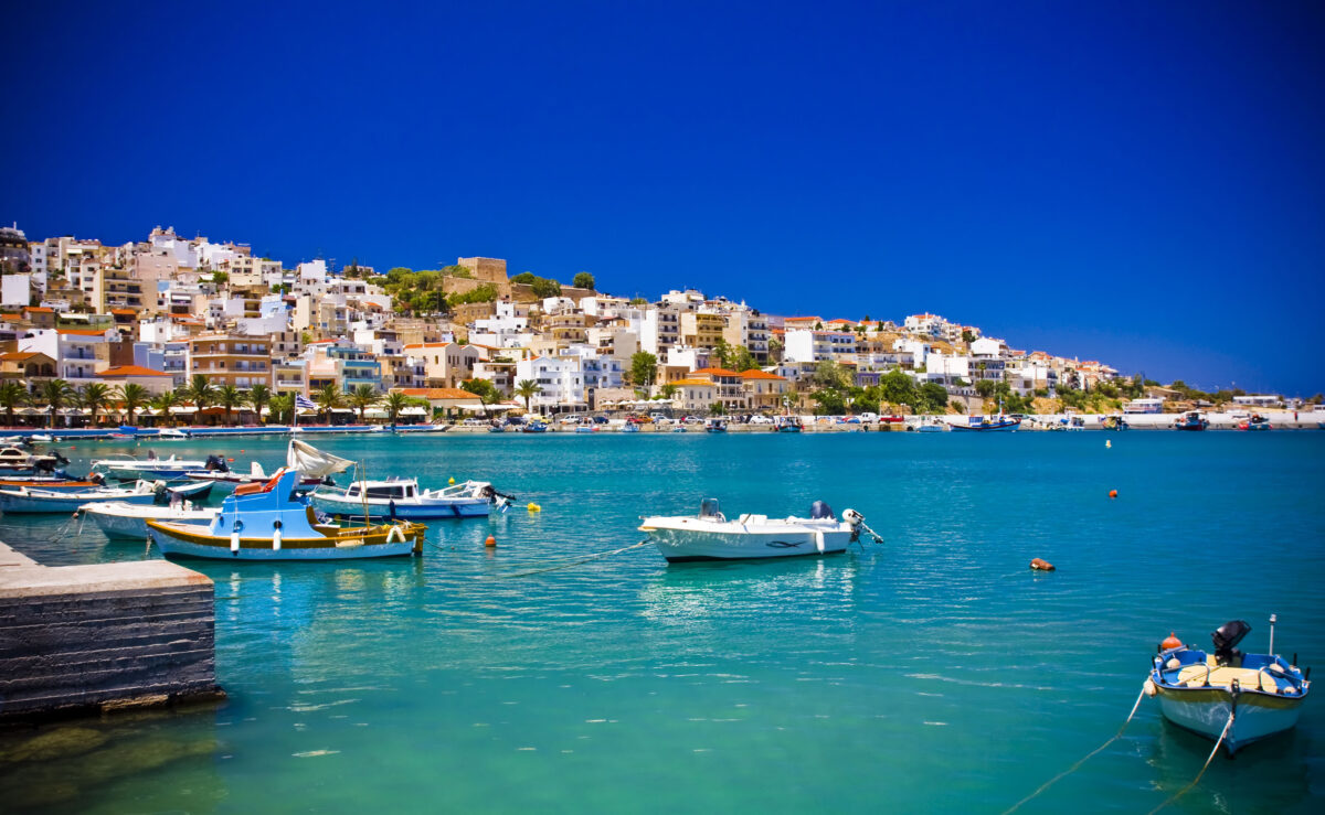 Sea bay with moored boats, promenade in Mediterranean town Sitia Greece Crete.