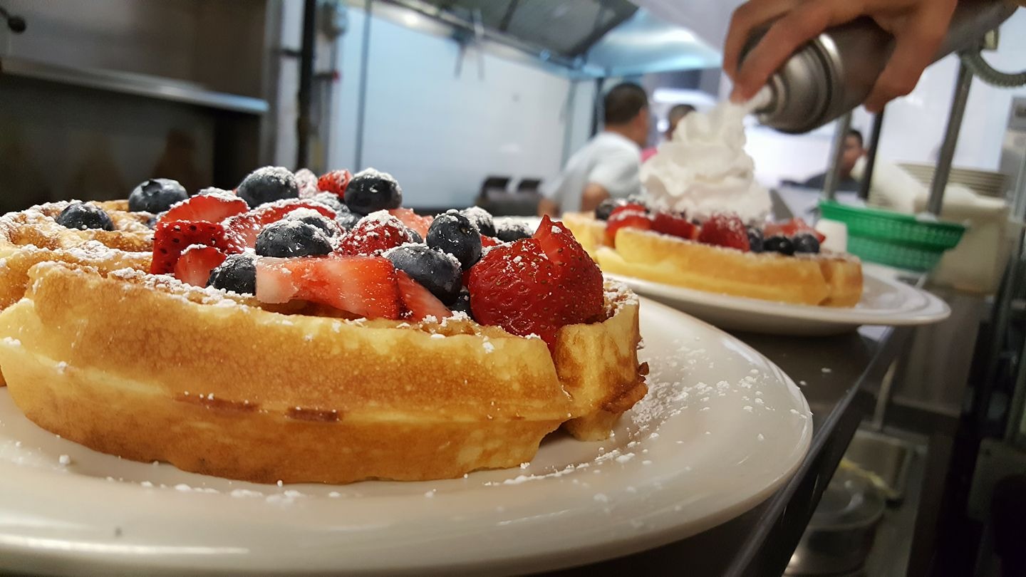 large waffles with fruit and sugar on top