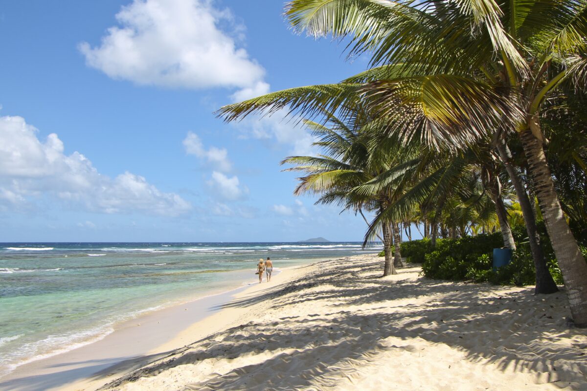 A couple walks down a resort beach on St. Croix, US Virgin Islands.