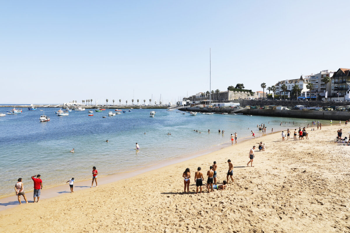Tourists enjoy Ribeira Beach or Fisherman`s Beach, in the center of Cascais, in Lisbon District, in Portugal.
