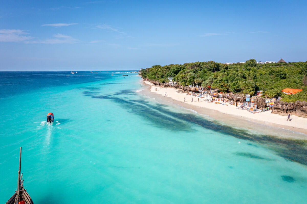 Tourists enjoy Nungwi Beach, Zanzibar, with its turquoise water and white sand