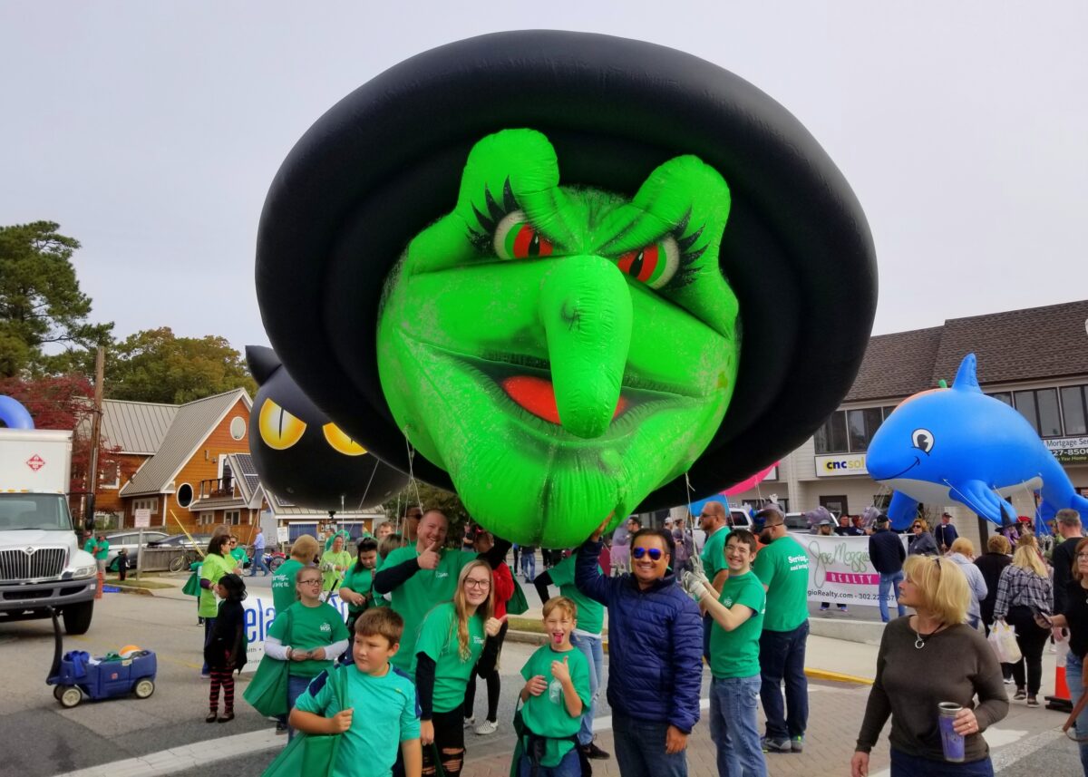 Rehoboth Beach, Delaware, A green witch float on Seawitch Festival parade and the marchers on the street.
