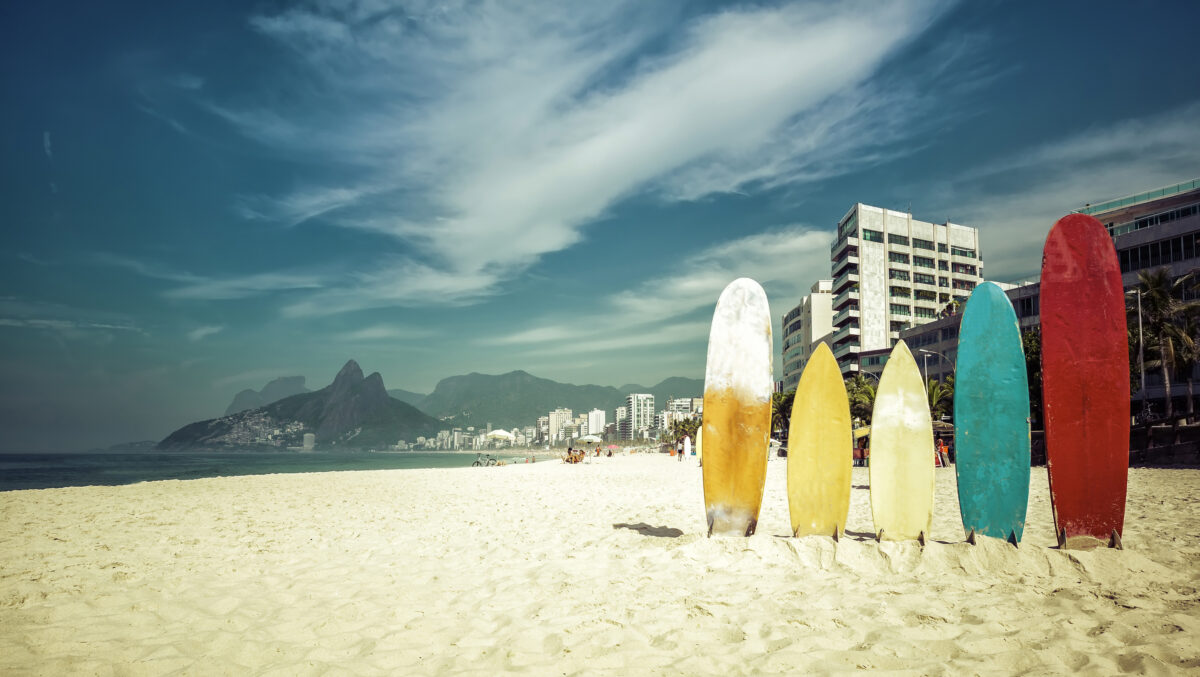 Surfboards standing in bright sun on Ipanema Beach.