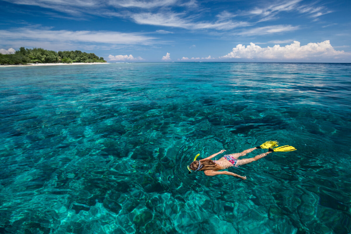 Lady snorkeling in turquoise water near Gili Trawangan island, Indonesia.