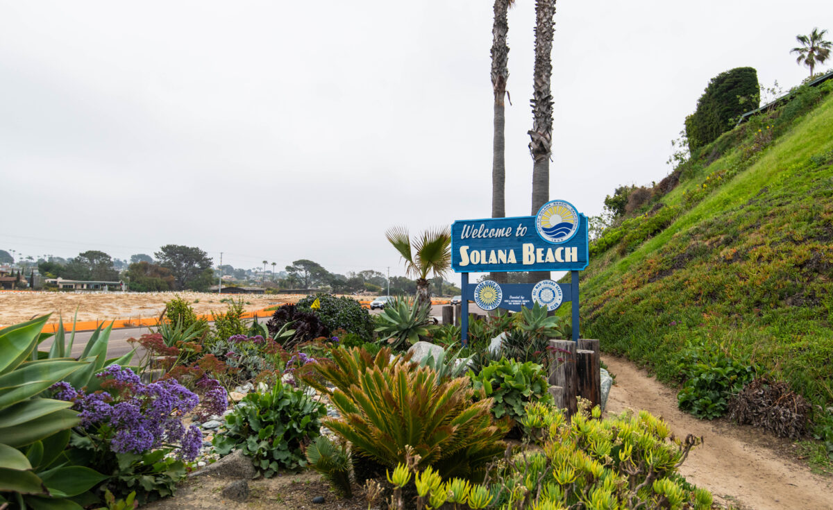Plants and lush floral vegetation surrounding the sign to enter Solana Beach, California.
