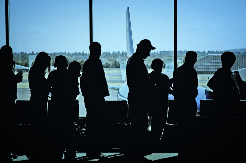 Travelers standing in line at the airport waiting to board an airplane