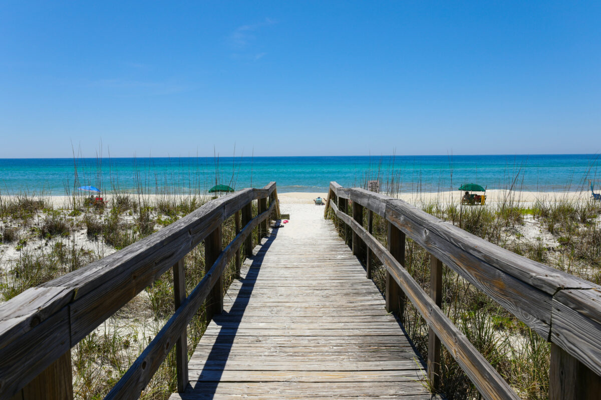 A beautiful view of a wooden path going to Henderson Beach State Park Destin in the USA