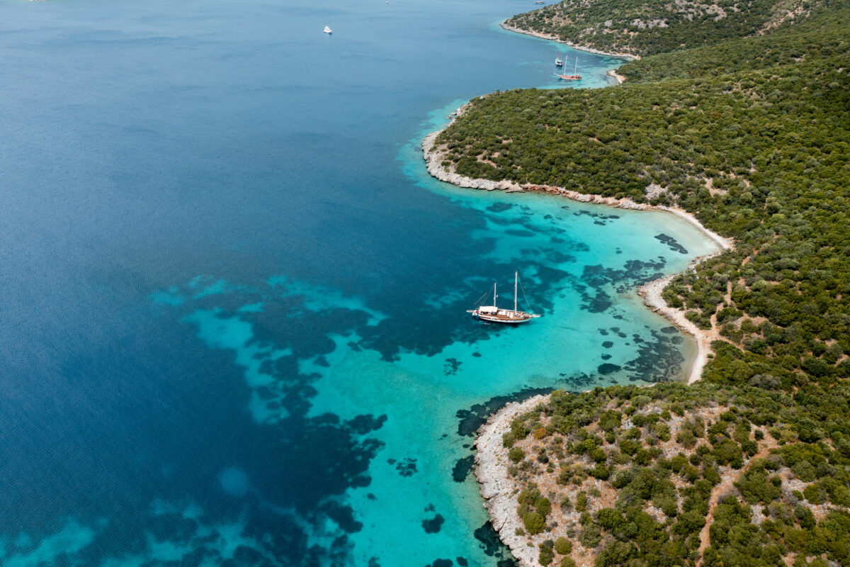 Gulet cruising along beautiful turquoise mediterranean coast in Bozburun Peninsula, Turkey.