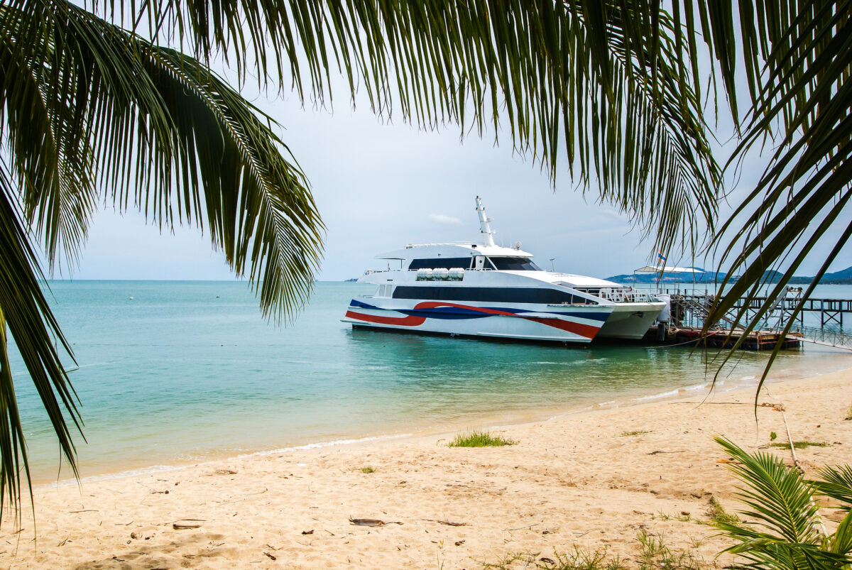 High-speed catamaran stands at the pier, located on a sandy beach. Koh Samui Thailand
