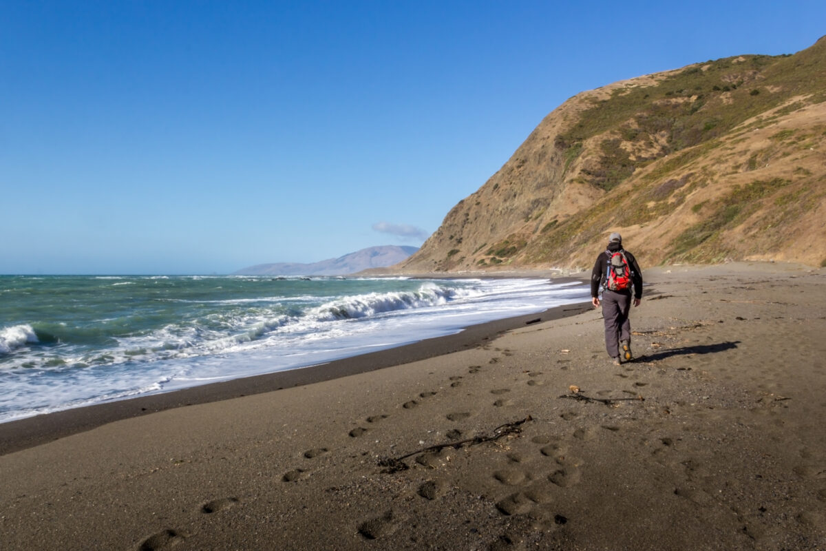 Man hiking on the lost coast along the Pacific ocean, California