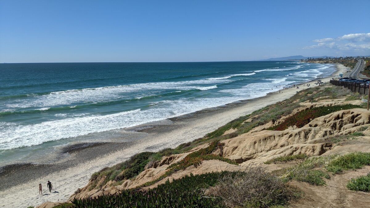A bright clear sunny day with the Pacific Ocean shimmering at South Carlsbad State Beach California.