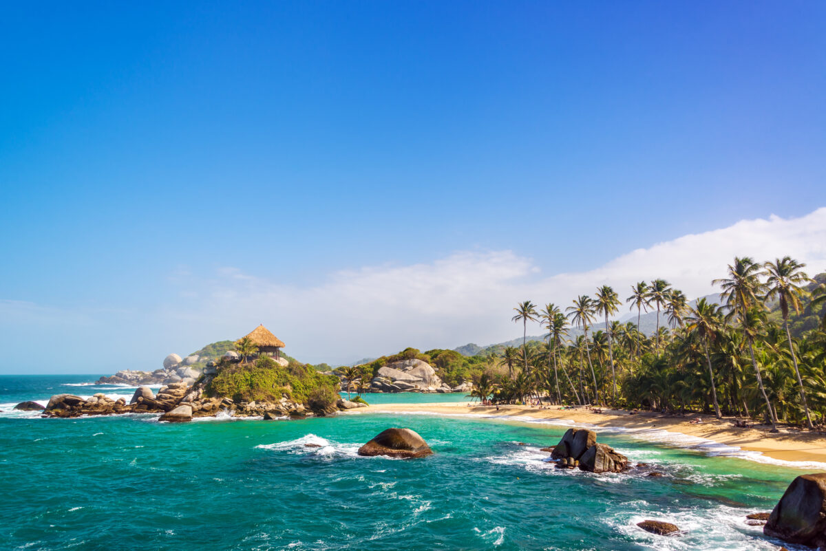 Palm trees and blue Caribbean water on the beach of San Juan del Guia in Tayrona National Park in Colombia