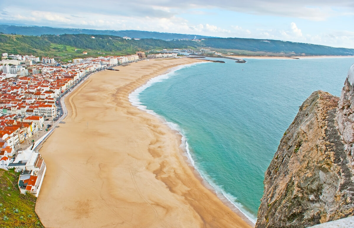 The sand beach of Praia district is seen from the hilltop of Nazare, Costa de Prata Silver Coast, Portugal.The sand beach of Praia district is seen from the hilltop of Nazare, Costa de Prata Silver Coast, Portugal
