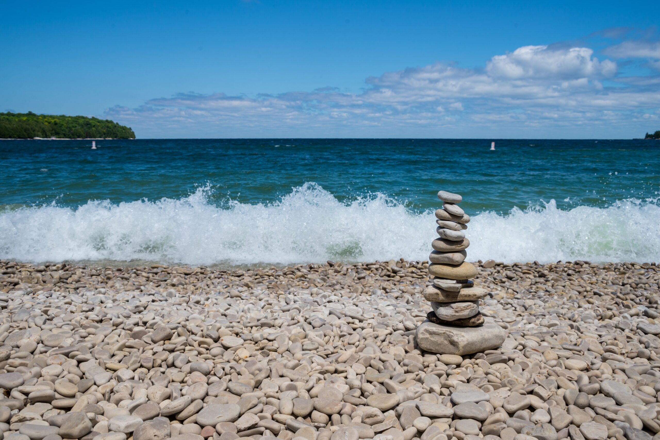 Stacked stones and crashing waves on school house beach in door County Wisconsin. Pile of stacked stones on school house beach in door County, Wisconsin
