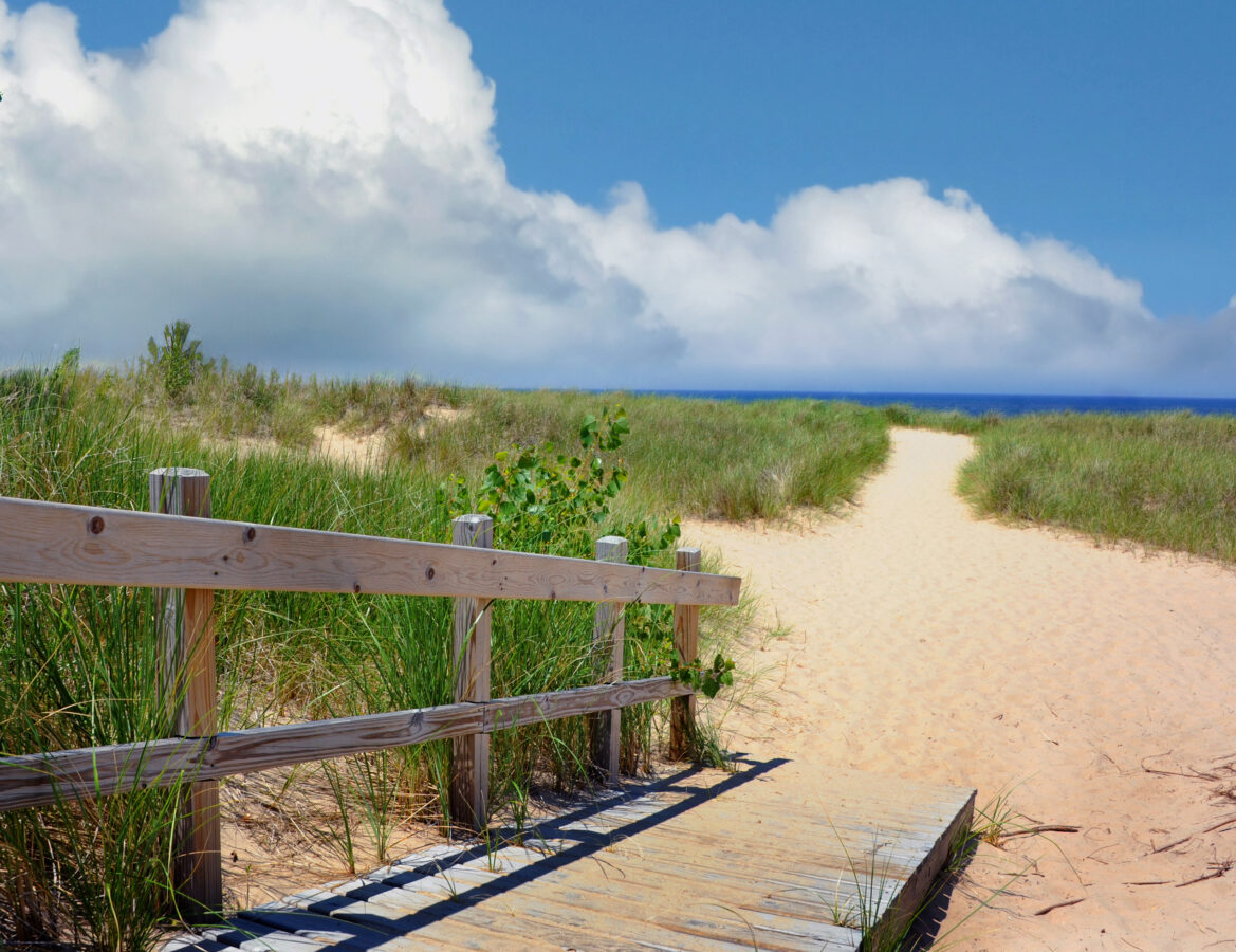 Trails to St. Joseph Lighthouse and Horizon. Trail over the sand dunes leads to the St. Joseph Lighthouse in Michigan. Wooden rail and ramp leads towards trail