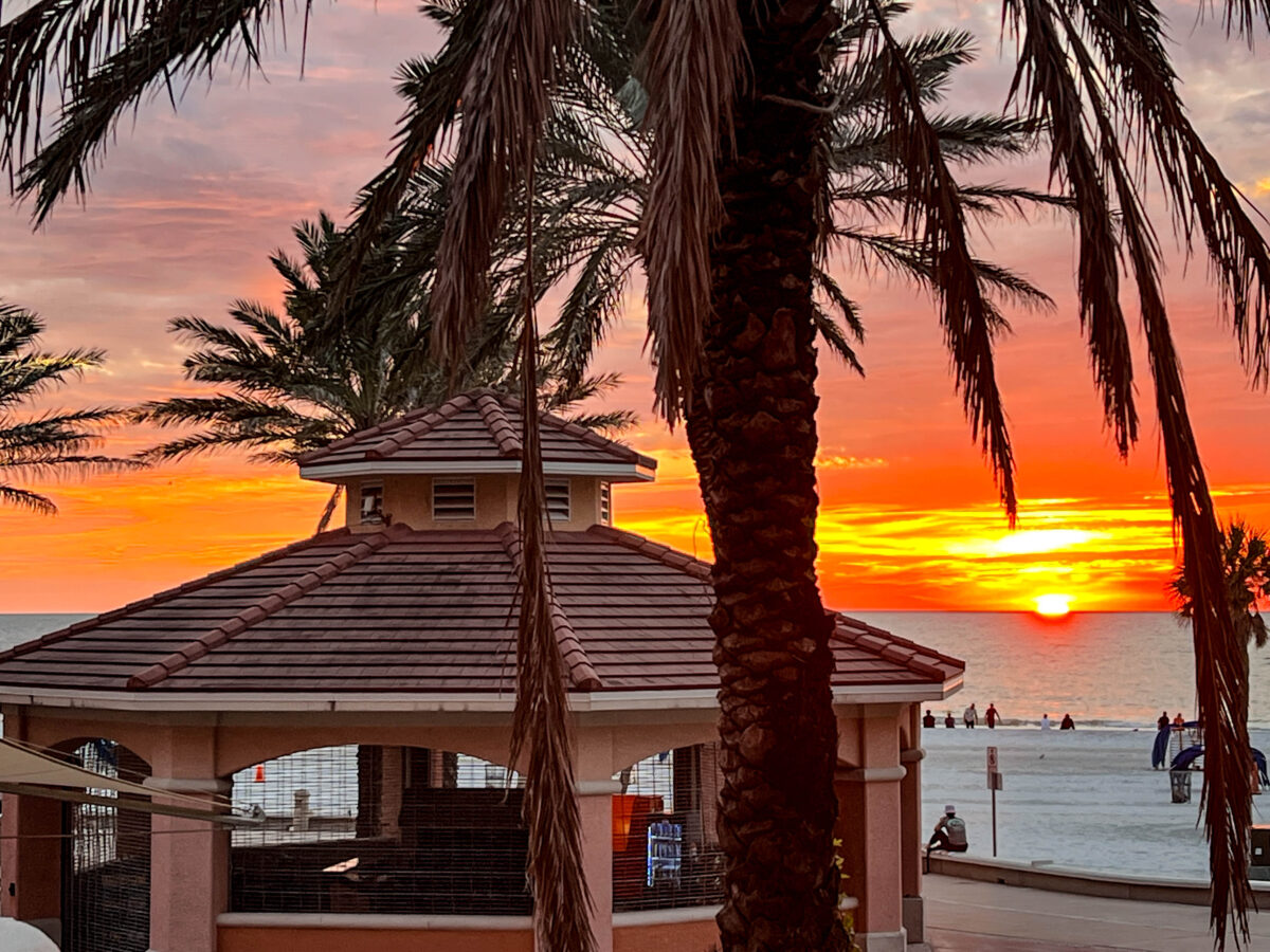 sunset with building palm tree and beach and water behind it_Clearwater Beach_Florida_Brandy Jo Hastings_