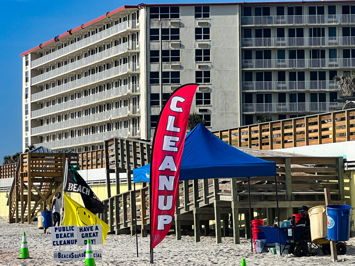 Red cleanup flag on beach with other flags and hotel in back_Daytona Beach_Florida_Brandy Jo Hastings