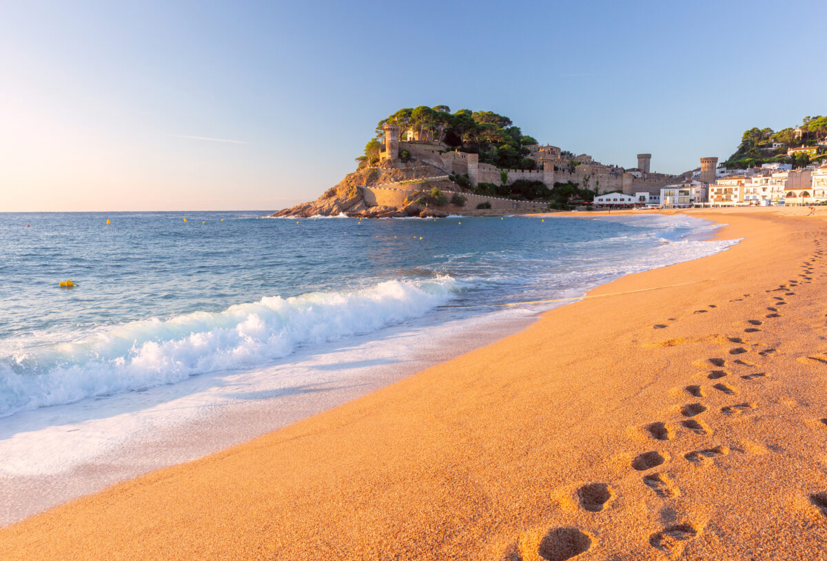 Beach and fortified old town at sunrise in Tossa de Mar, Spain