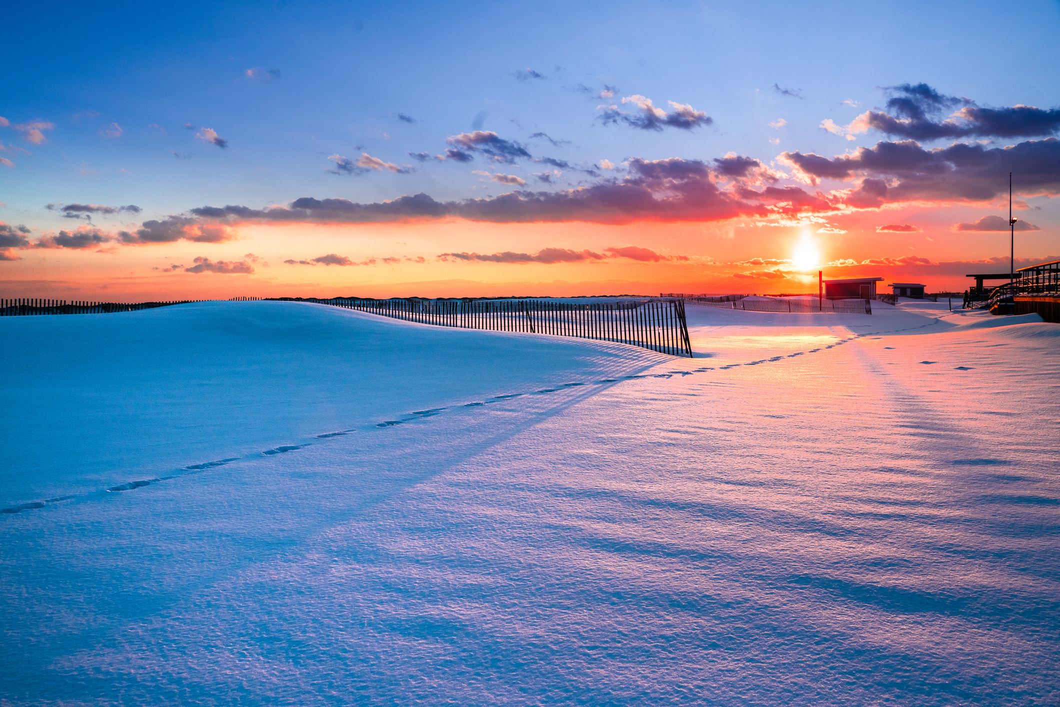 Winter scene under color sky at sunset on snow covered beach at Jones Beach State Park in Long Island NY.