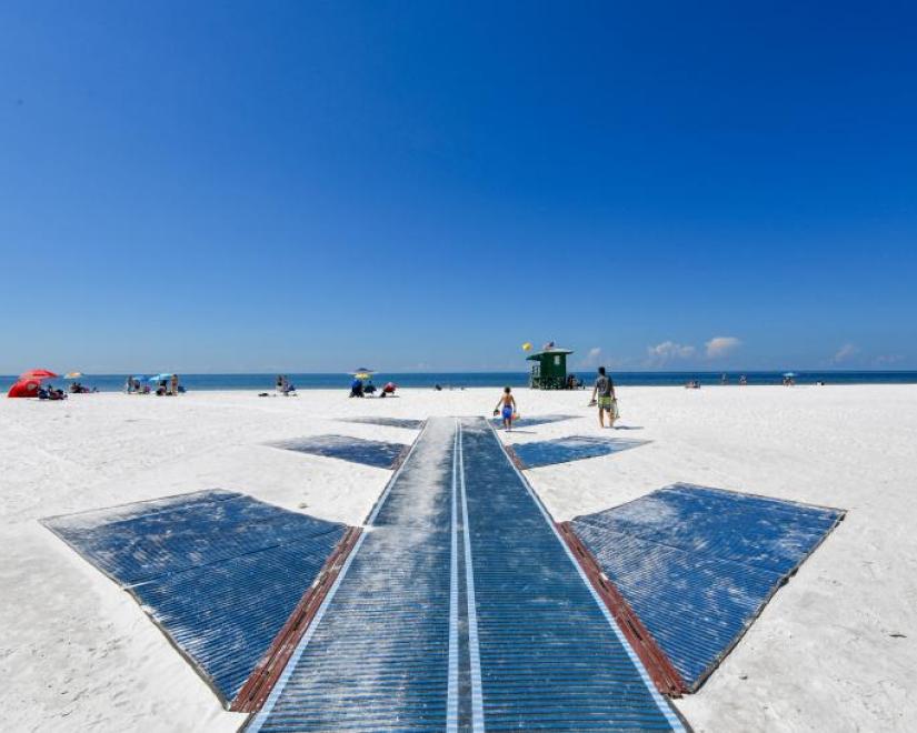 A long beach mat with side wings extends across the sand to the shore at Siesta Key Beach.