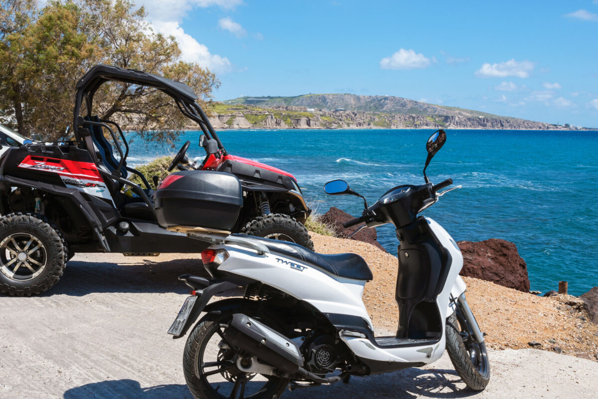 Scenic view of the turquoise sea, blue sky, clouds on the island of Santorini, Greece. Rent a vehicle for travel. ATV and scooter. Greek travel
