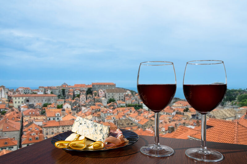 Two glasses of red wine with charcuterie assortment on view of Dubrovnik red roofs